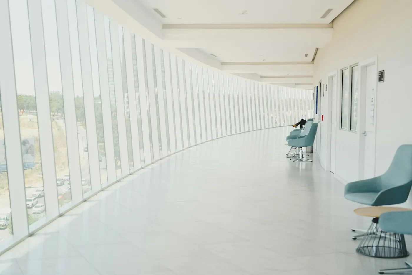 Corredor hospitalar iluminado por luz natural, em fotografia ilustrativa.